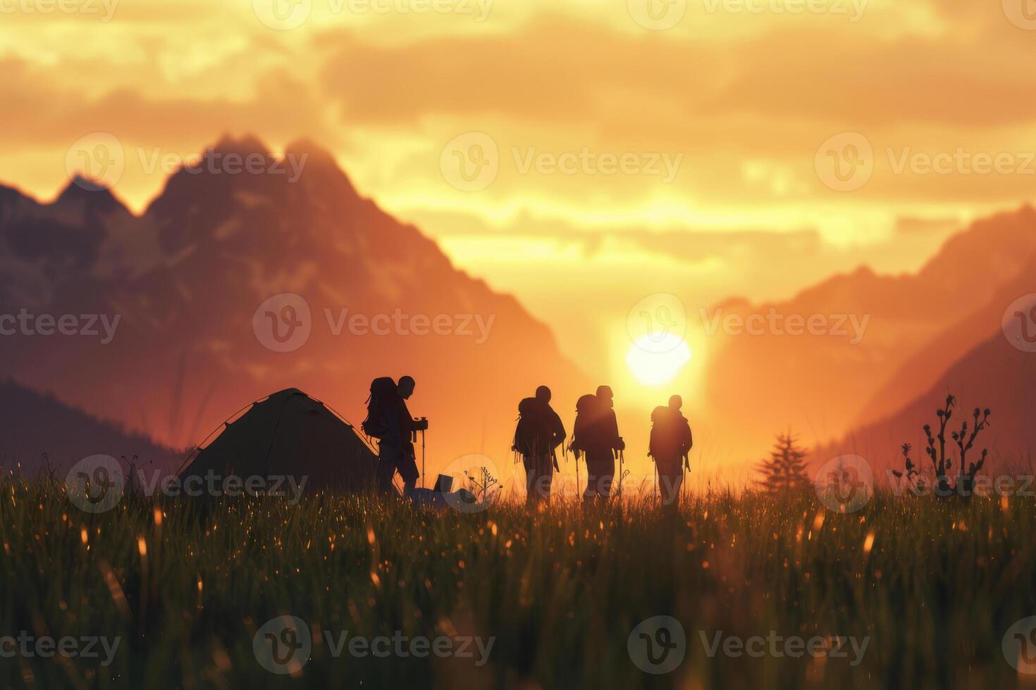 Sunset camping trip with silhouettes of hikers and tent in a meadow. Blurred mountains on a background. photo