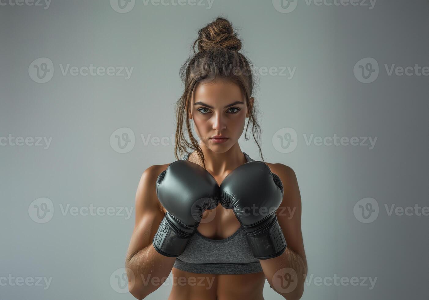 Confident female boxer with black gloves in strong stance, showing power, fitness, and determination photo