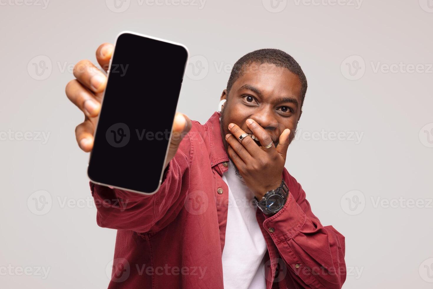 Surprised african young man showing smartphone screen and rejoicing at success, on white background, photo