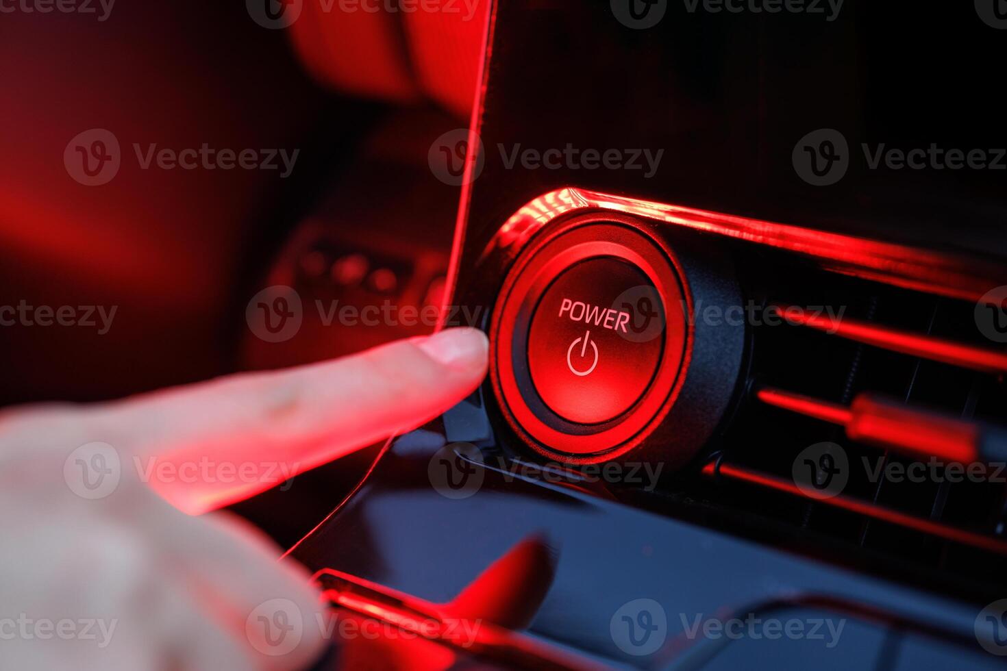Hand pressing power button on modern black dashboard, event activation concept photo