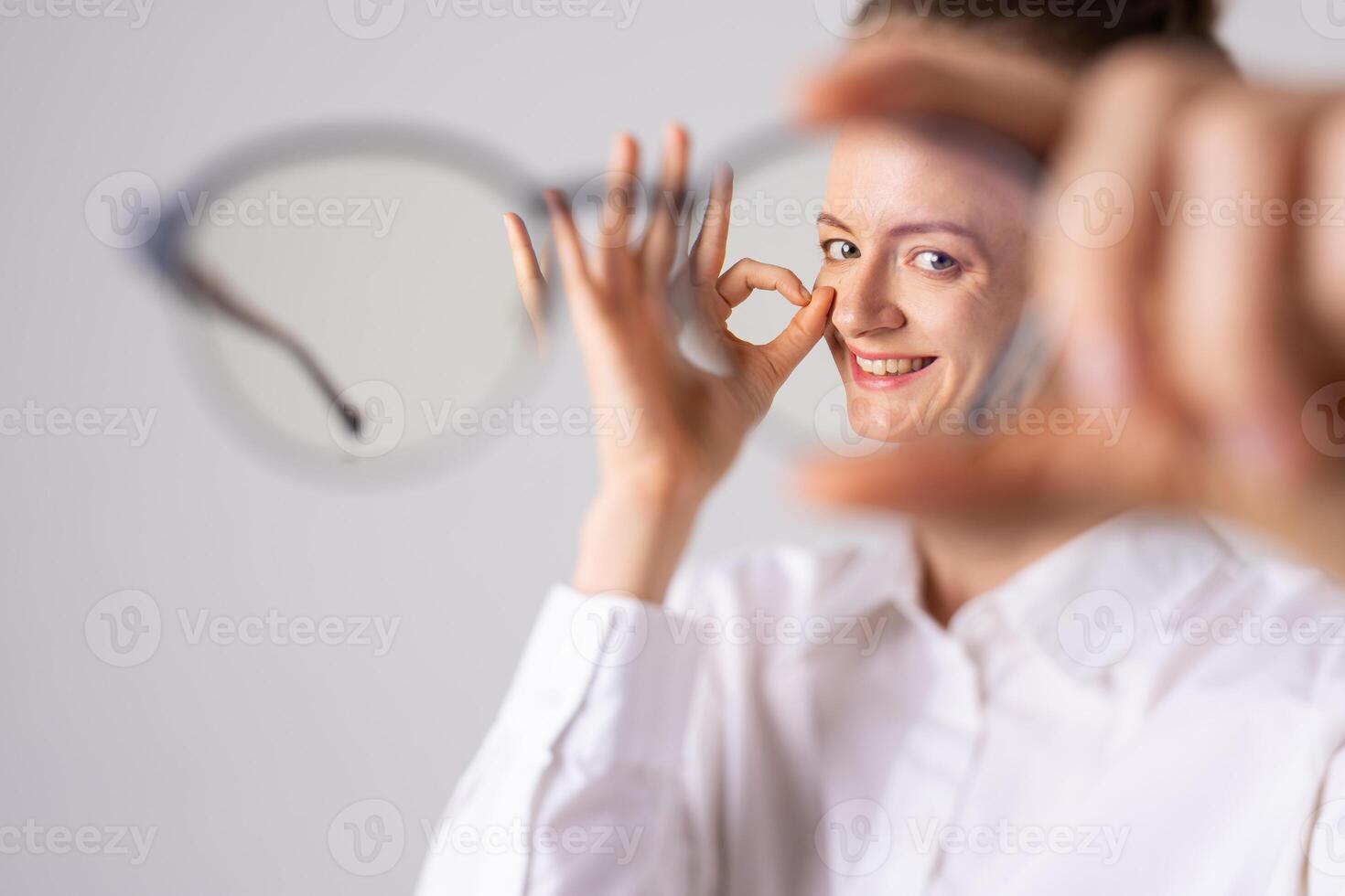 Poor vision concept, woman with poor vision holding glasses in front of her photo