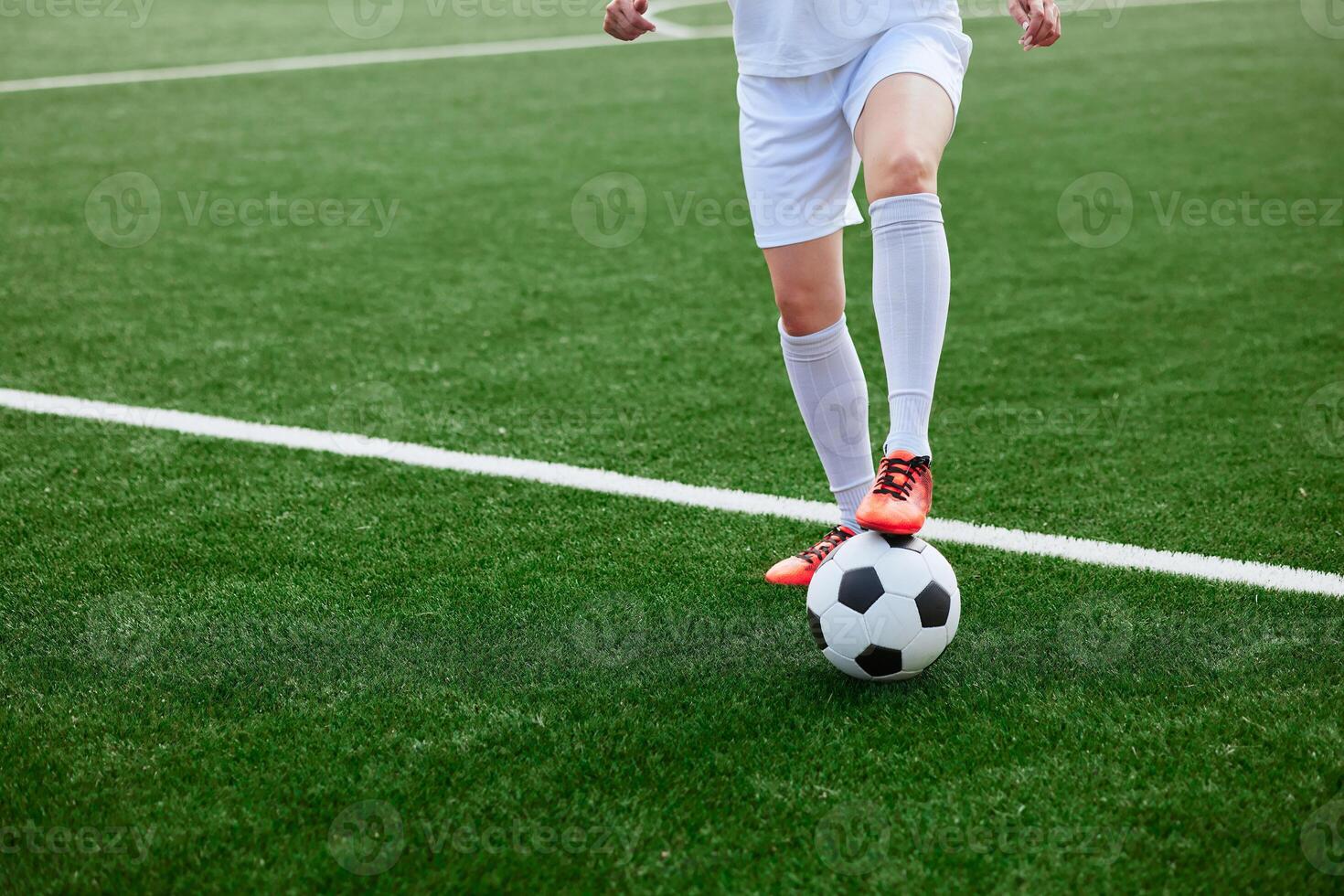 And the soccer player in the uniform and red clothes controlling the soccer ball on the Green Field photo
