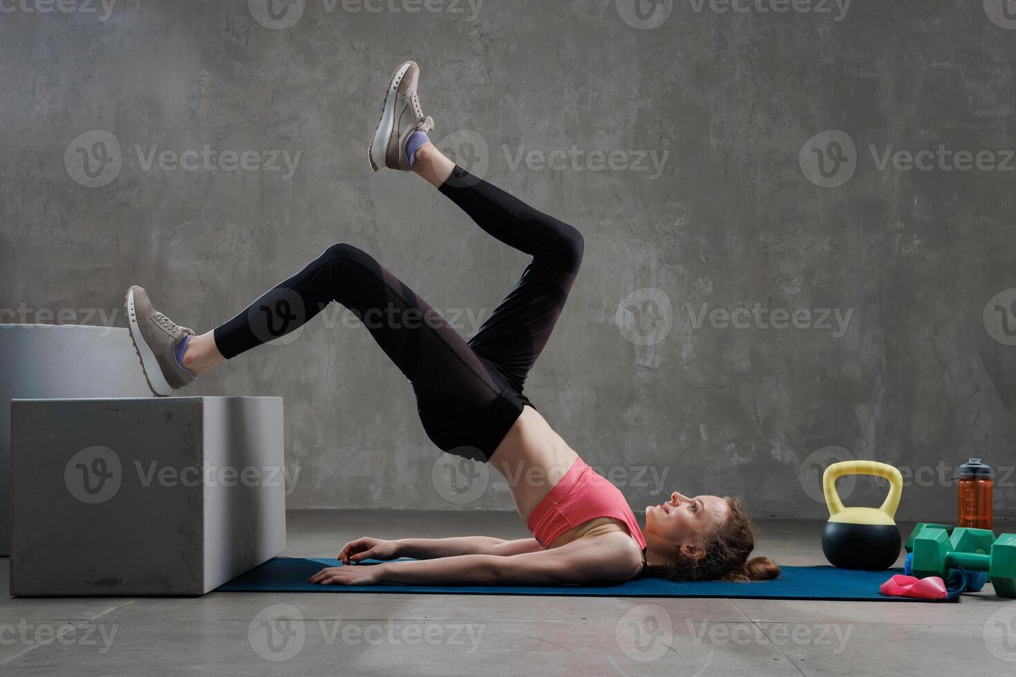 Woman performing single-leg glute bridge exercise photo