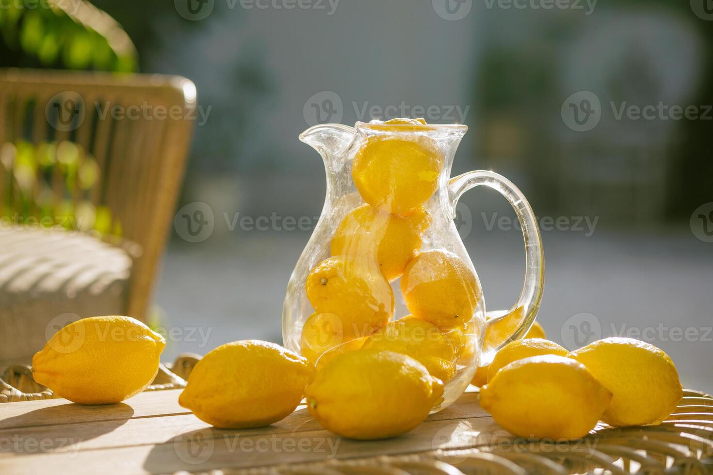 A pitcher of lemonade with sliced lemons and oranges on a table photo