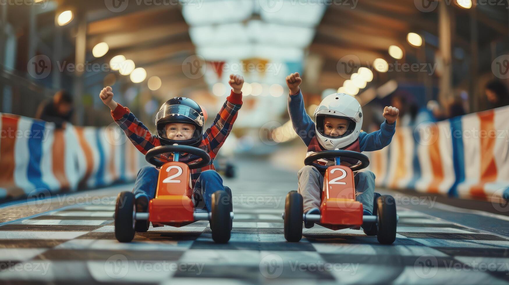 Two children in helmets riding on a race track photo