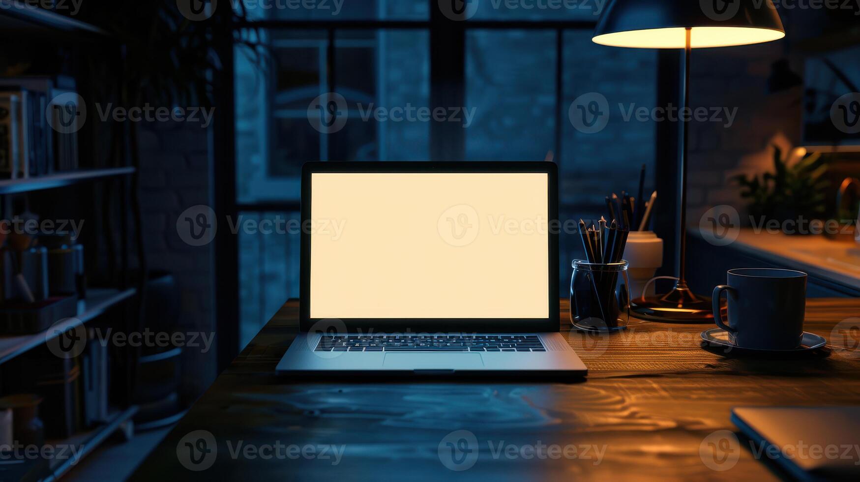 A laptop sitting on a desk in front of a lamp photo