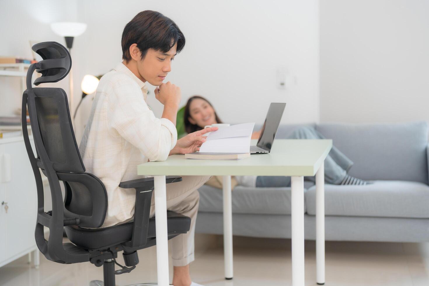 Modern home office with working man and relaxing woman photo