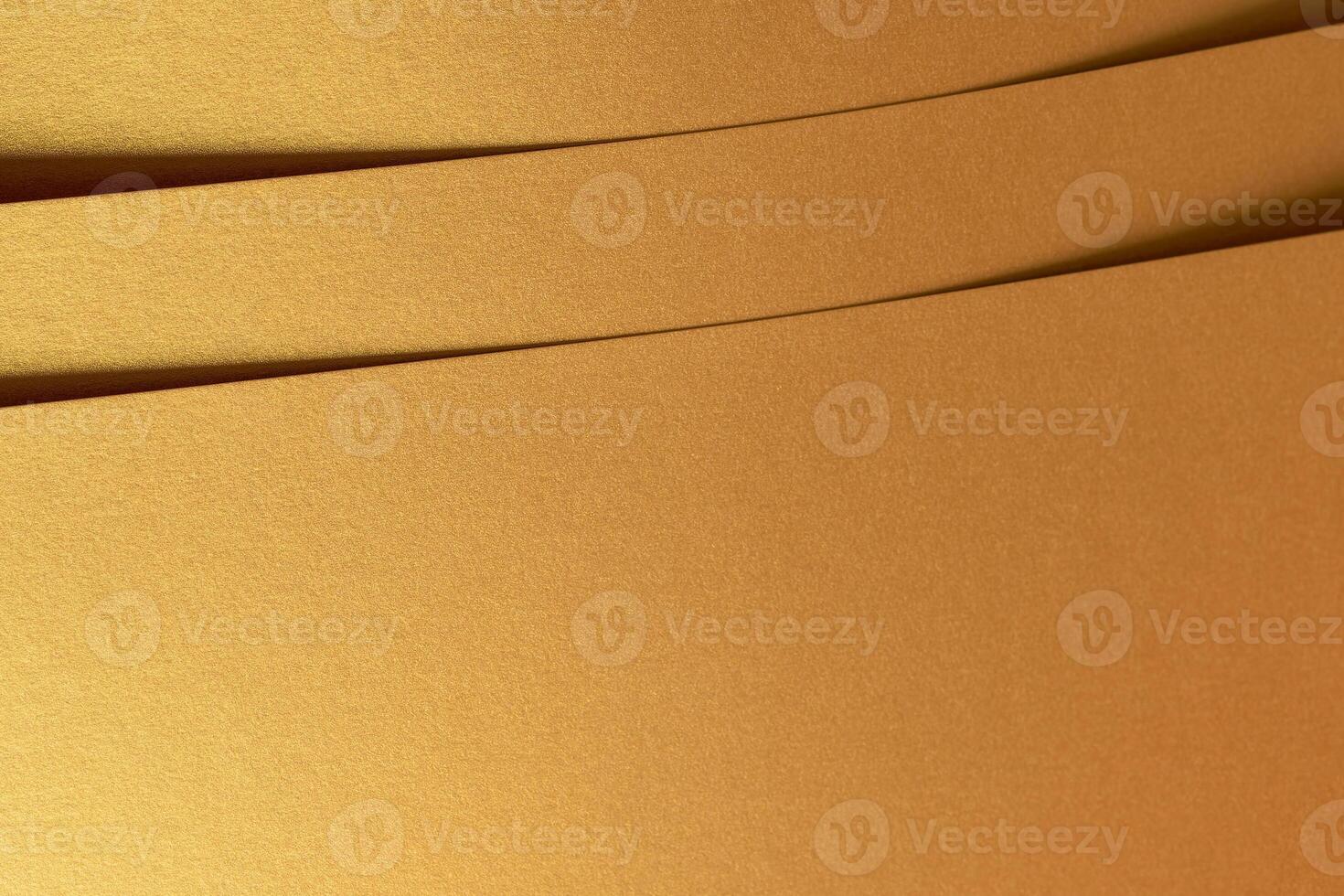 Golden metallic paper with a layered texture and shiny surface in brass and yellow tones. The photo