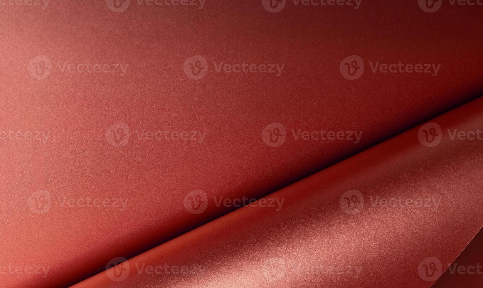 Red metallic paper with a glossy, reflective texture and smooth folds. Scarlet surface with abstract photo