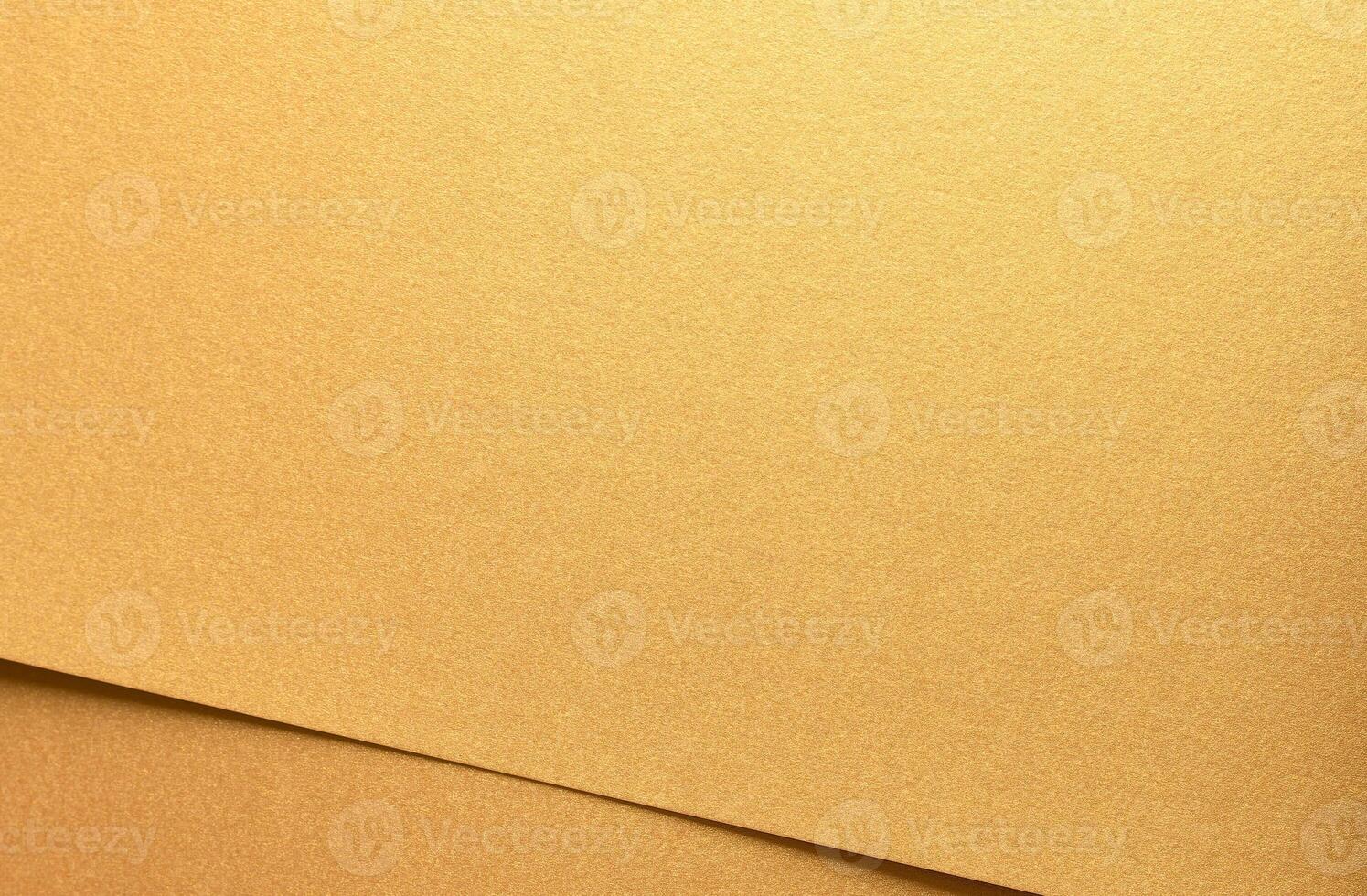 Golden metallic paper with a glossy texture and layered folds. The rich, warm surface shines with photo