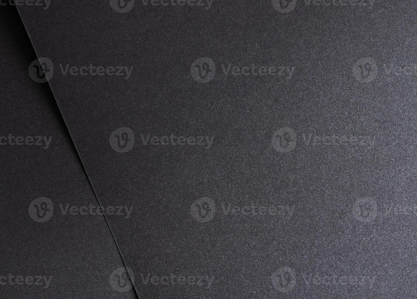 Black paper background with a smooth, dark texture, creating a grunge and modern aesthetic. Blank photo
