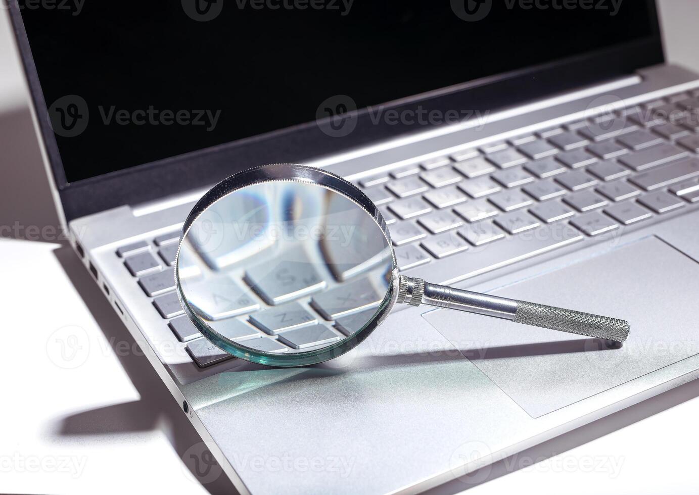 SEO search concept with magnifying glass on a website. Web research and engine optimization in a photo