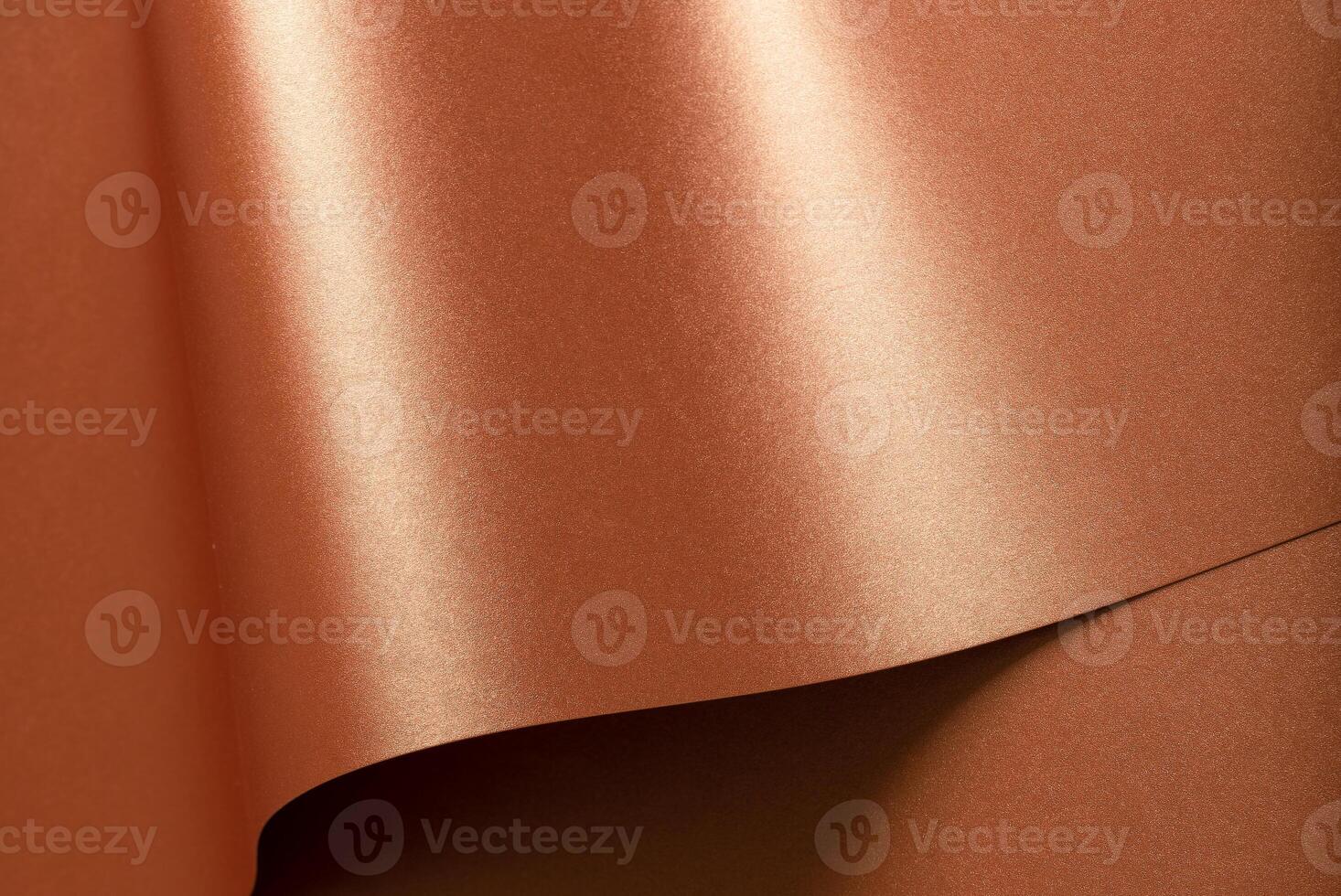 Copper metallic texture with glossy, reflective folds. Designer paper with a smooth, shiny surface photo