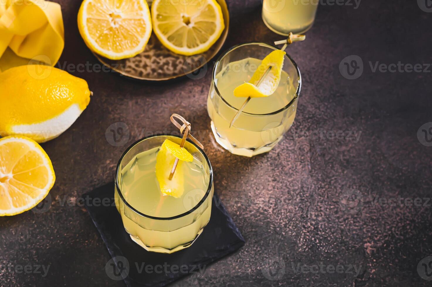 Two glasses of Italian limoncello and lemons on the table photo
