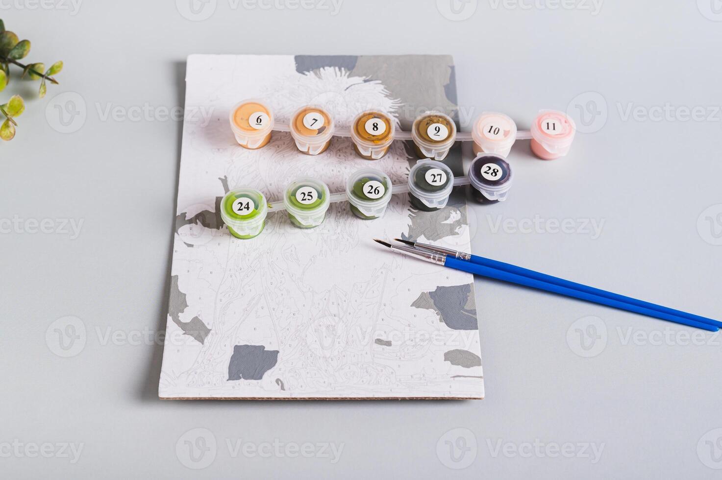 Unfinished paint by numbers painting and painting supplies on table photo
