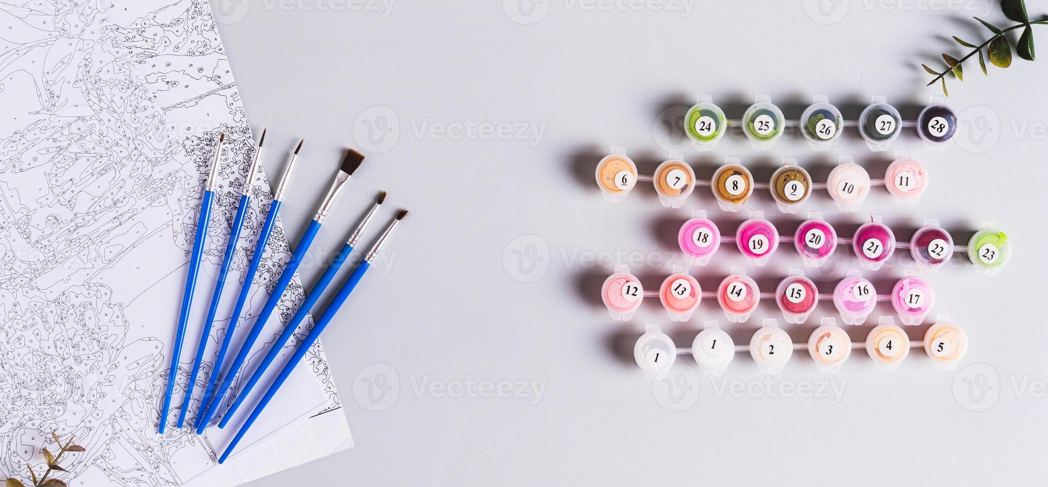 Acrylic paints, brushes and canvas for painting by numbers top view web banner photo