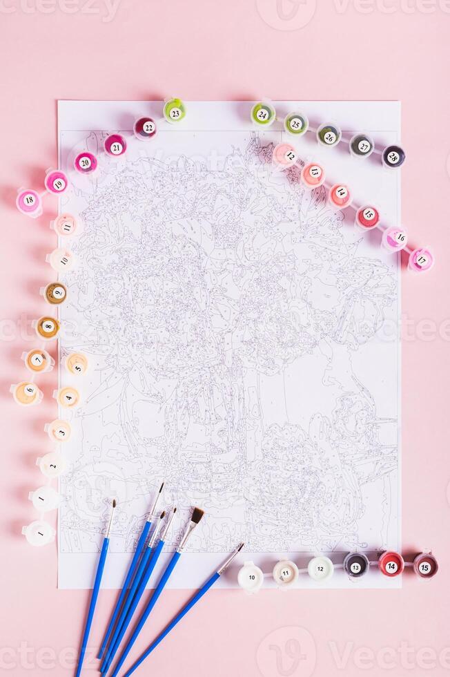 Painting by numbers kit and paper with diagram on pink background top and vertical view photo