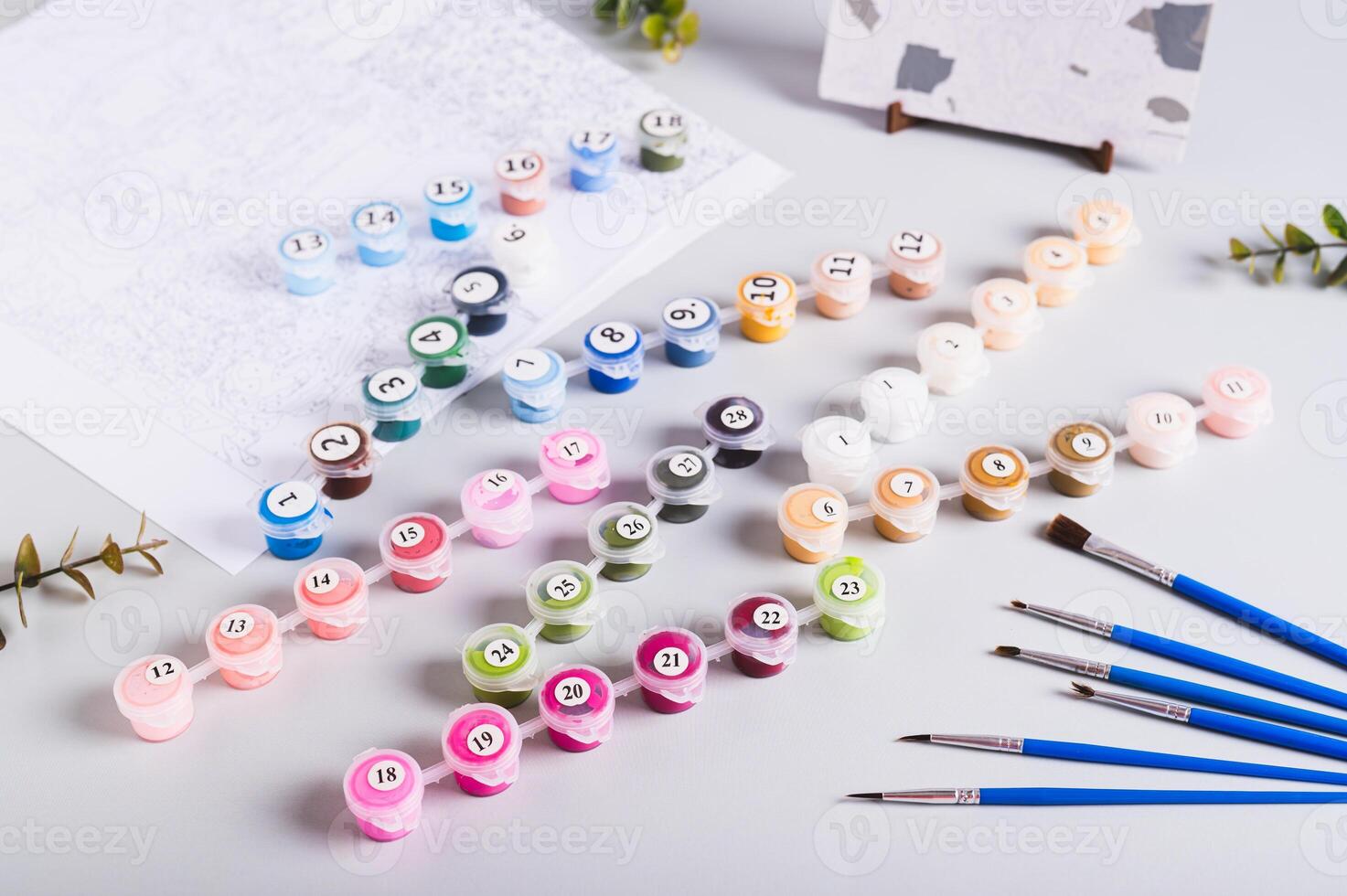 Acrylic paints, brushes and canvas for painting by numbers on the table photo