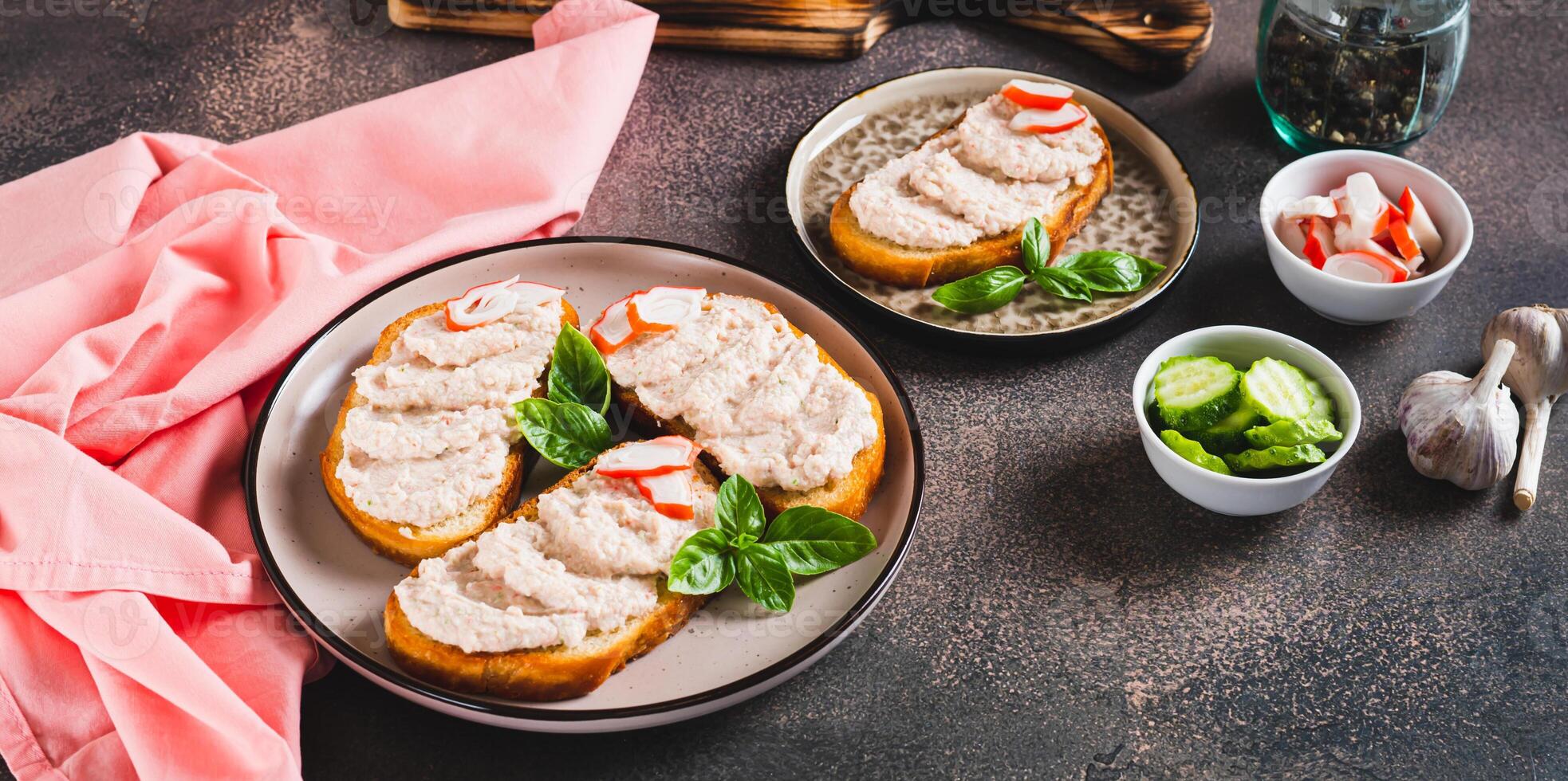 Crab stick and cucumber pate on toast on a plate on the table web banner photo