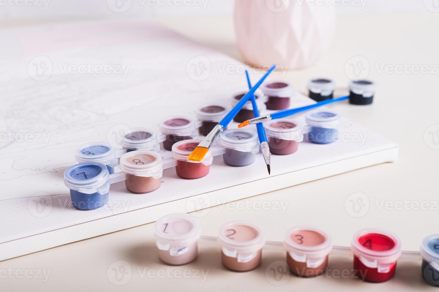 Brushes, multi-colored acrylic paints and canvas for painting by numbers on table photo