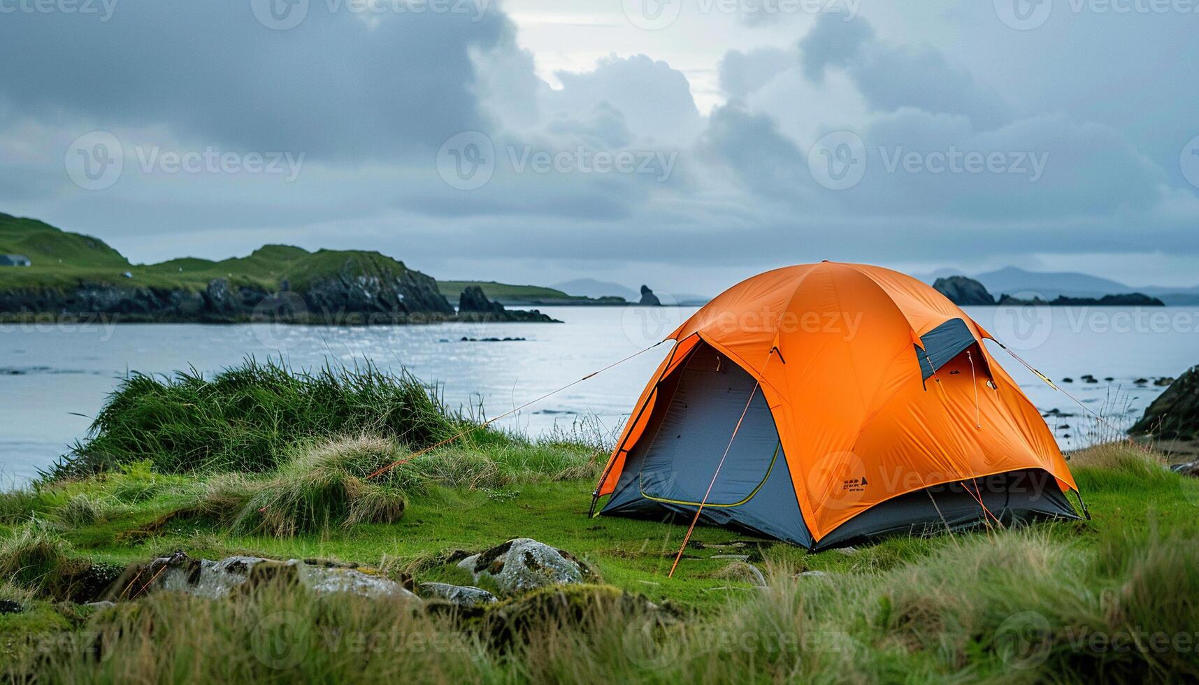 Camping trip, orange tent on the shore of Irish island background wallpaper backdrop. Copy space, travel, outdoors activity, nature near a lake photo