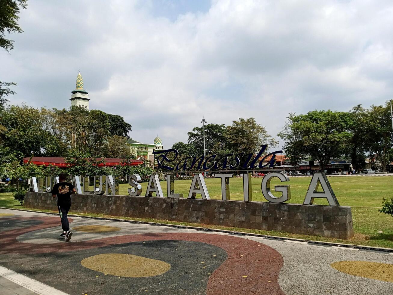 Central Java, Indonesia - November 21th 2023, a man is jogging in Pancasila Square, Salatiga City. This central public square is a popular gathering spot for locals and tourists photo