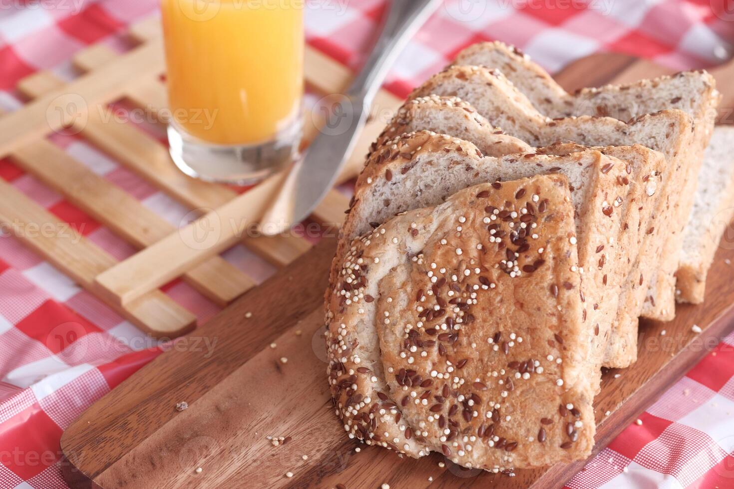 Deliciously Fresh Sliced Bread accompanied by a Glass of Orange Juice on a Checkered Tablecloth photo