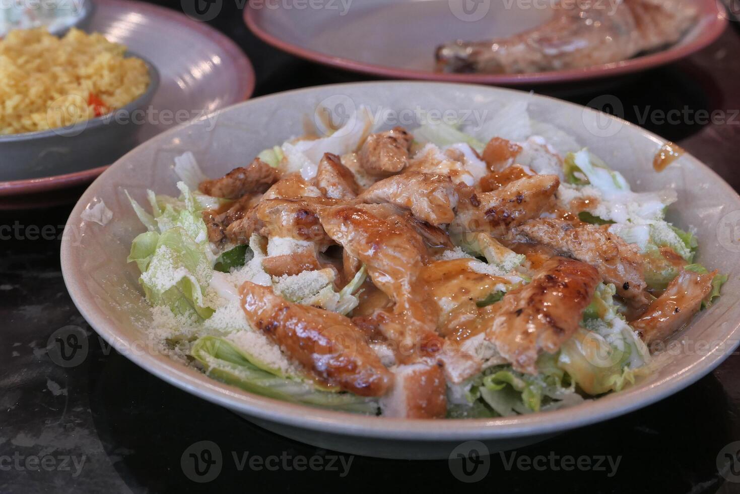 A mouthwatering Grilled Chicken Salad featuring Fresh Vegetables and a delectable Dressing photo