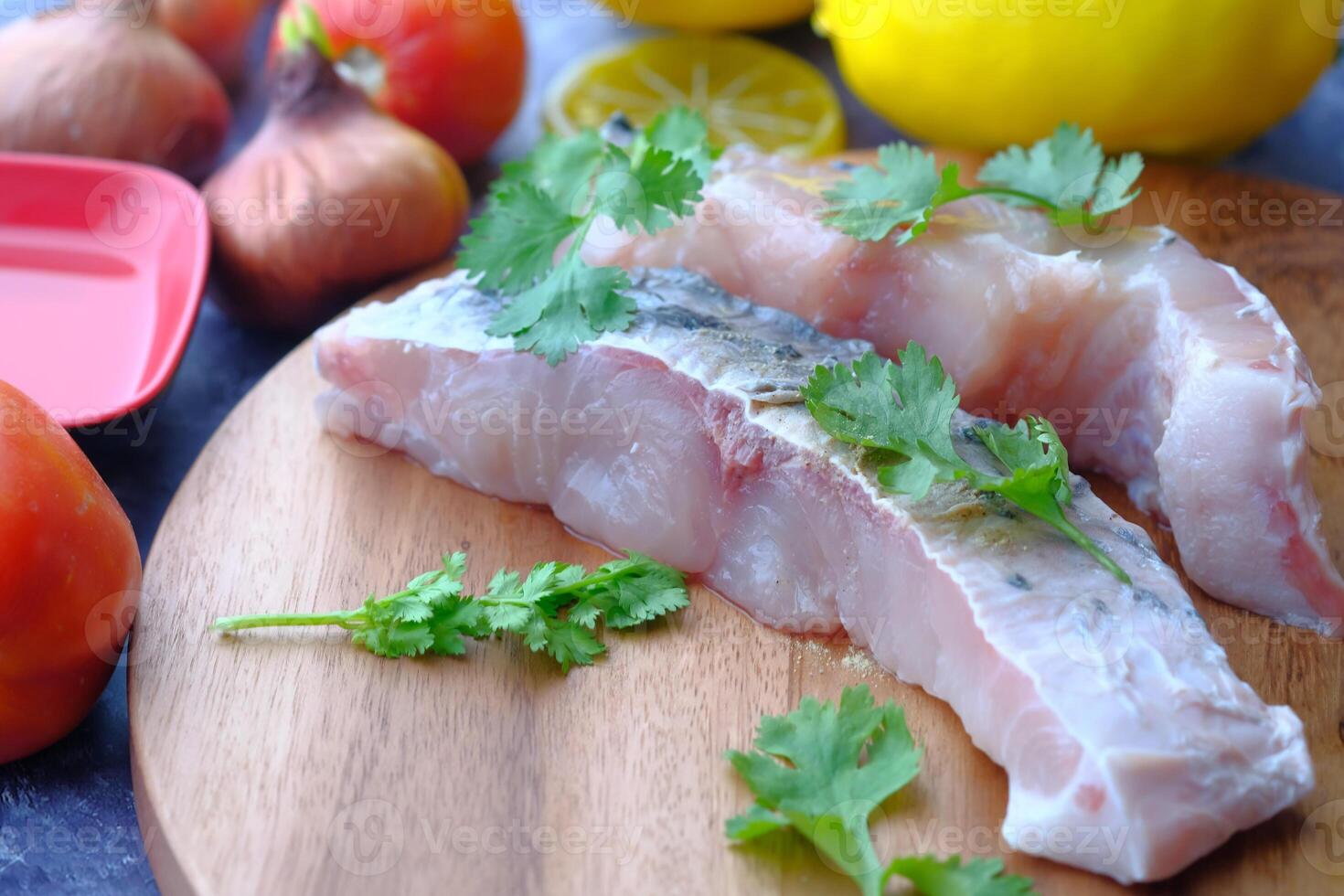 Delicious and Fresh Fish Fillets with Flavorful Herbs and Zesty Citrus on a Wooden Board photo