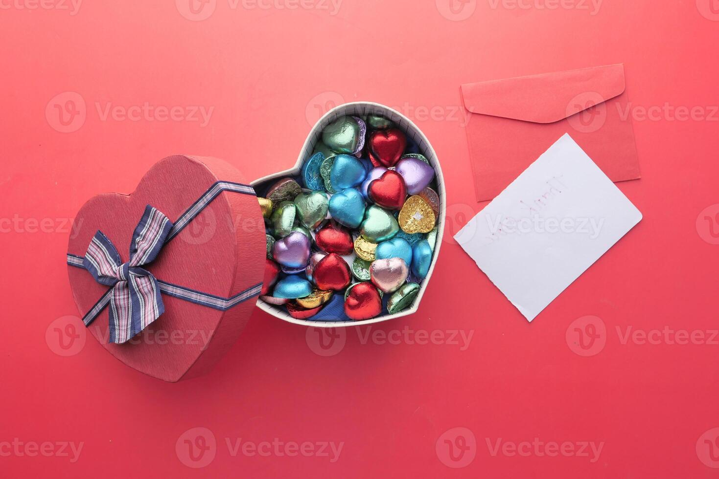 A HeartShaped Box Filled with a Variety of Colorful Chocolates Accompanied by a Note photo