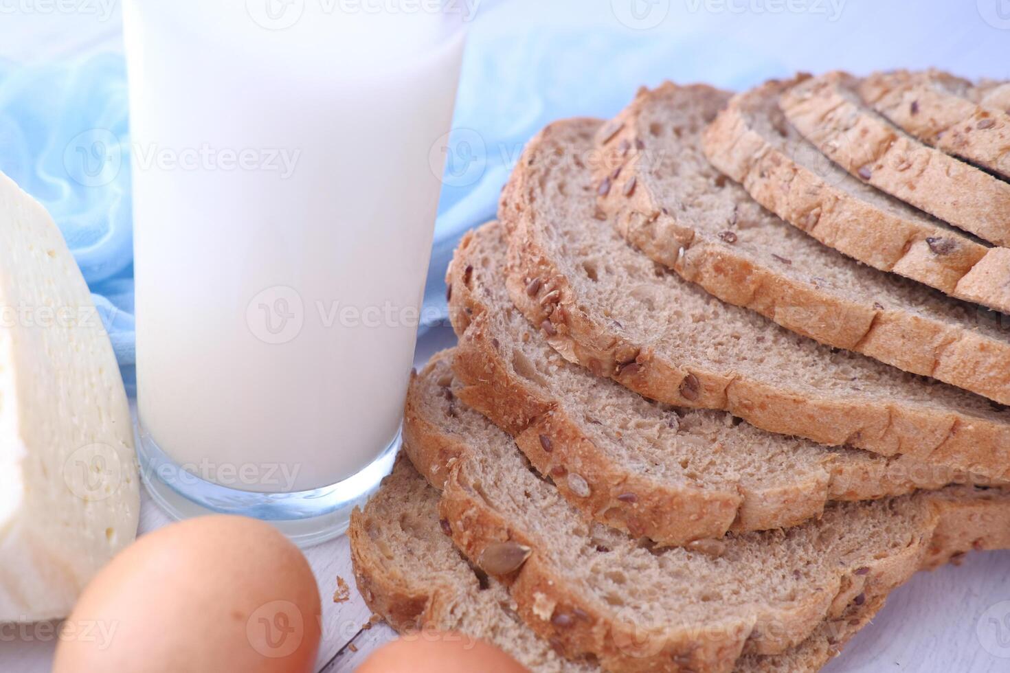 A nutritious breakfast includes Whole Grain Bread, fresh Milk, Eggs, and Cheese photo