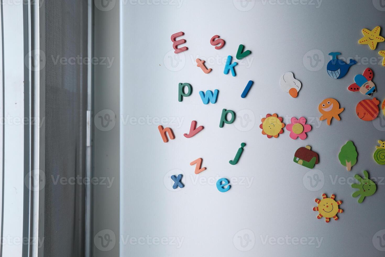 A vibrant assortment of Colorful Magnetic Letters and Shapes displayed on a Refrigerator Door photo