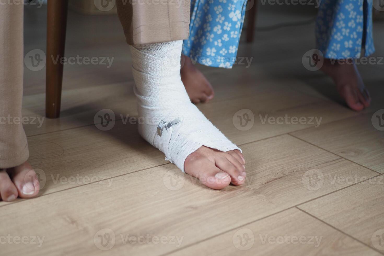 An injured foot wrapped in a bandage is gently resting on the floor, awaiting care and healing photo