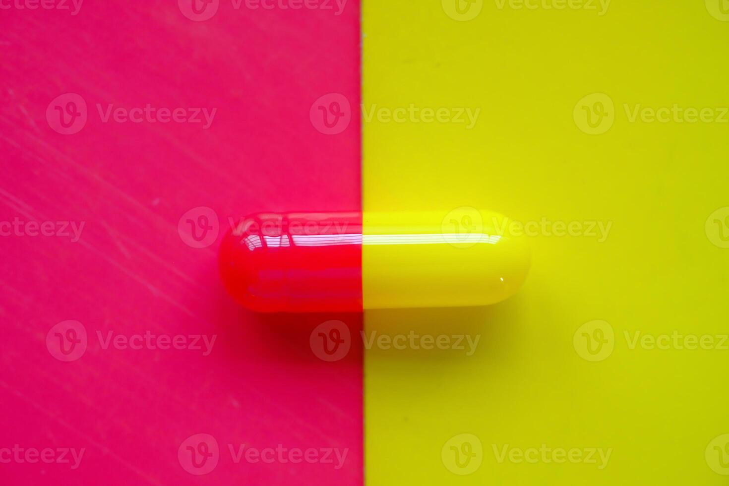 A Vibrant and Colorful DualColor Capsule Set Against a Striking Neon Background photo