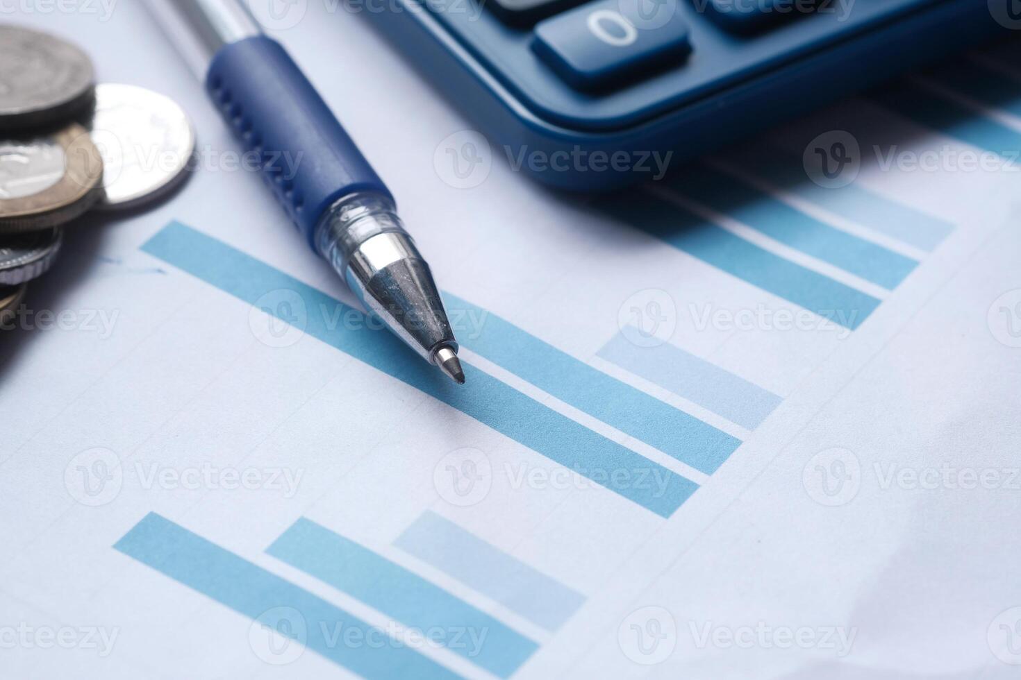 Various Financial Analysis Tools Including a Calculator, Pen, Coins, and Graph Paper photo