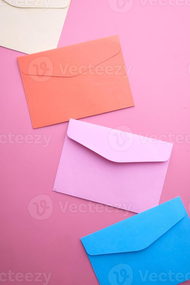Vibrant and Colorful Envelopes on a Soft Pink Background for Innovative and Creative Design photo