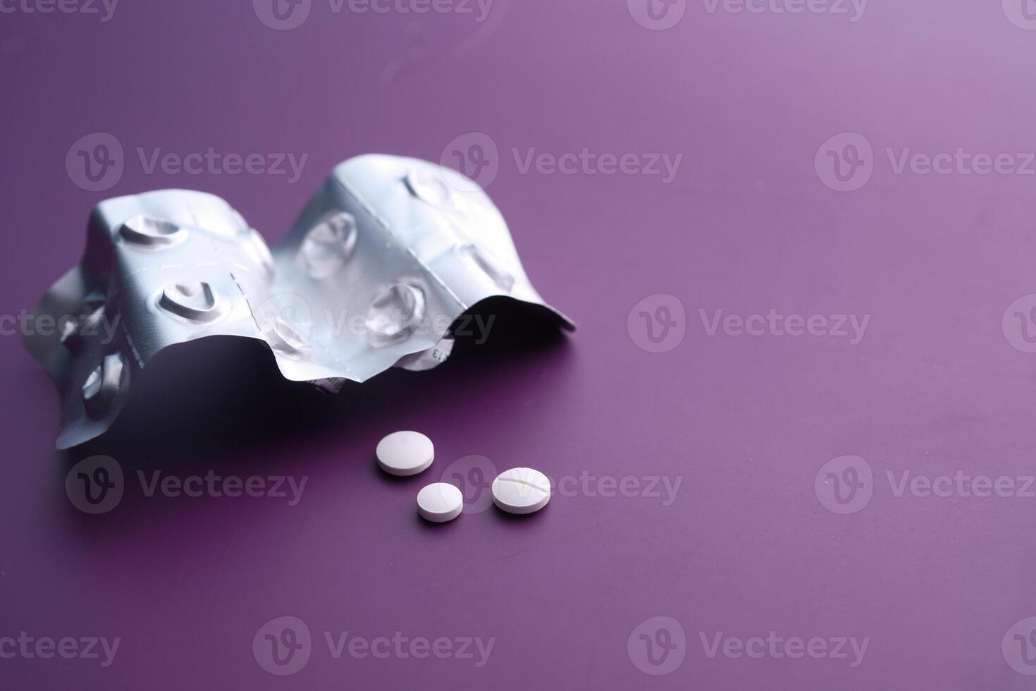 A Blister Pack of Various Medications with Colorful Pills on a Vibrant Purple Background photo