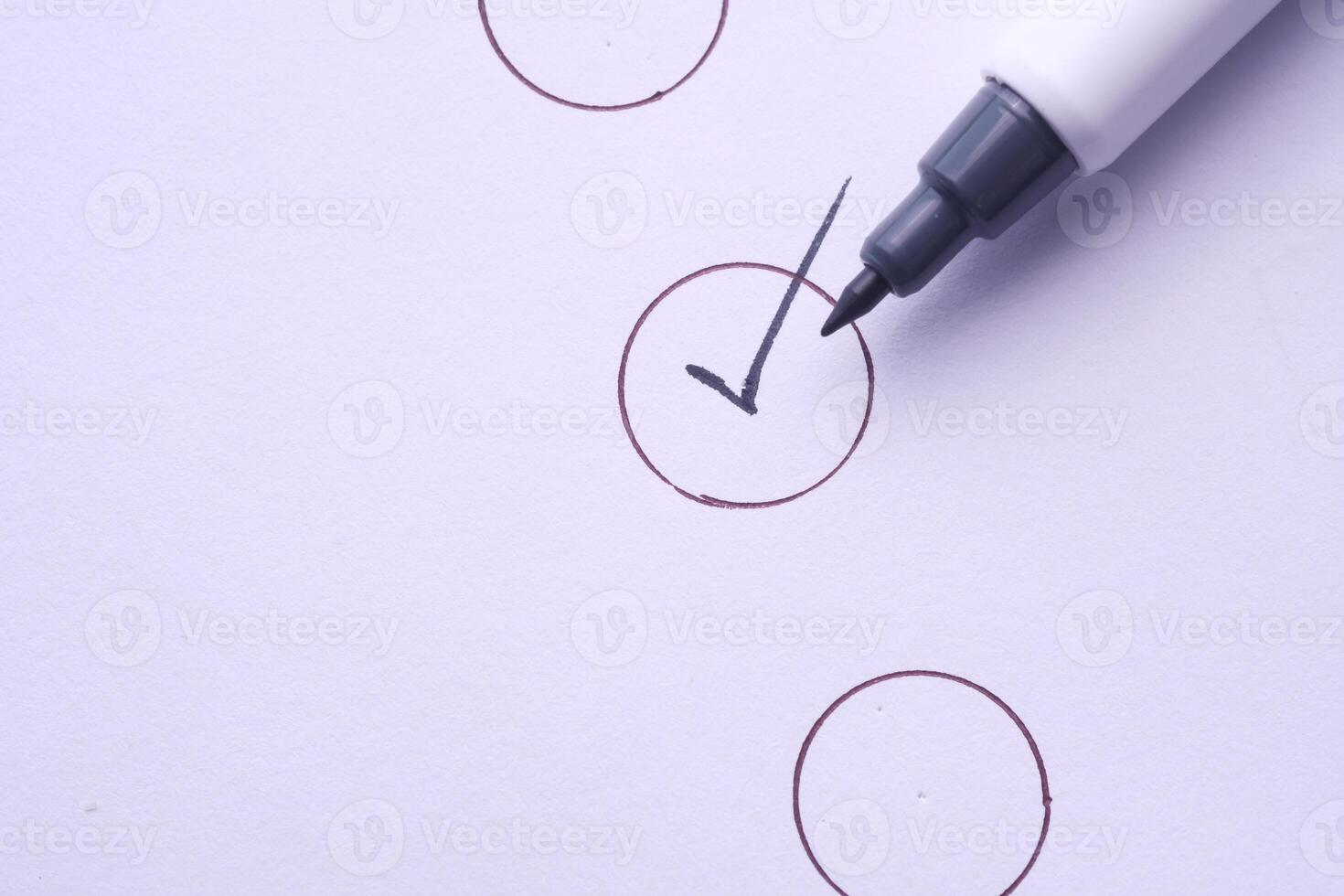 A checked checkbox is illustrated with a marker on a clean white background surface photo