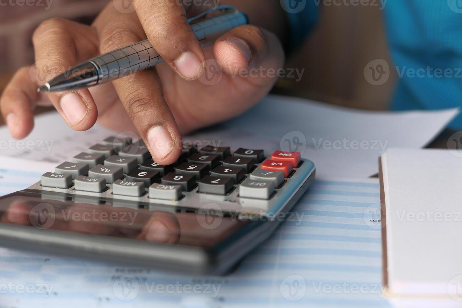 A person is diligently using a calculator for various financial calculations and planning purposes photo