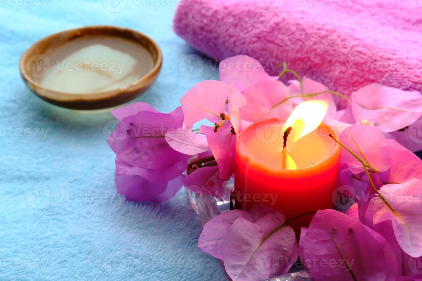 Imagine a spa scene with a glowing candle and vibrant bougainvillea petals for tranquility photo