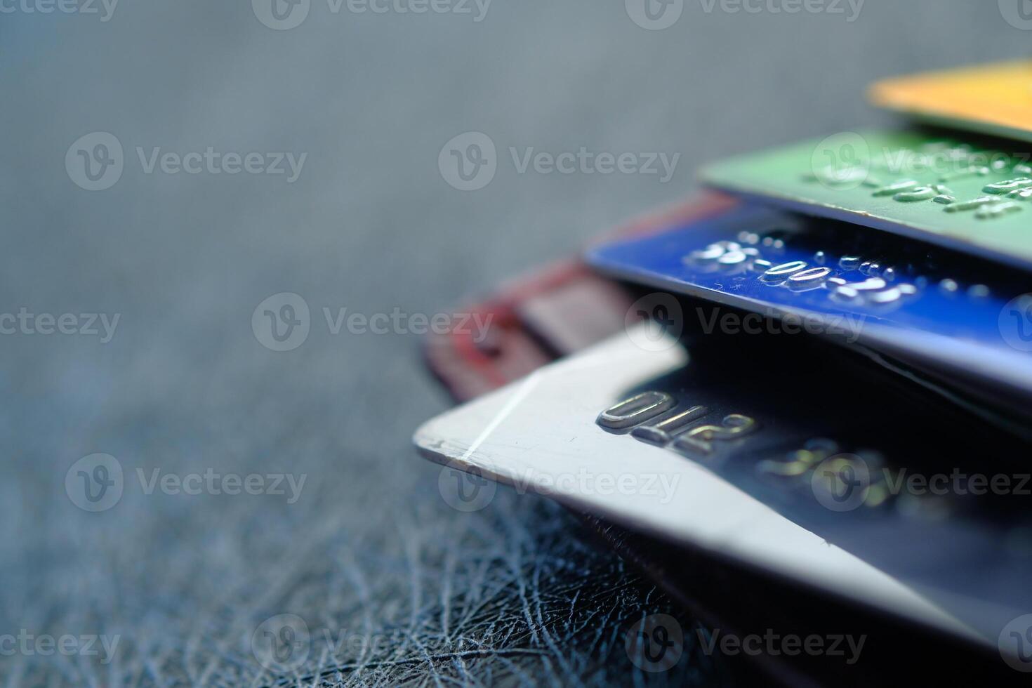 A Stack of Various Credit Cards Arranged Neatly on a Textured Background Surface photo