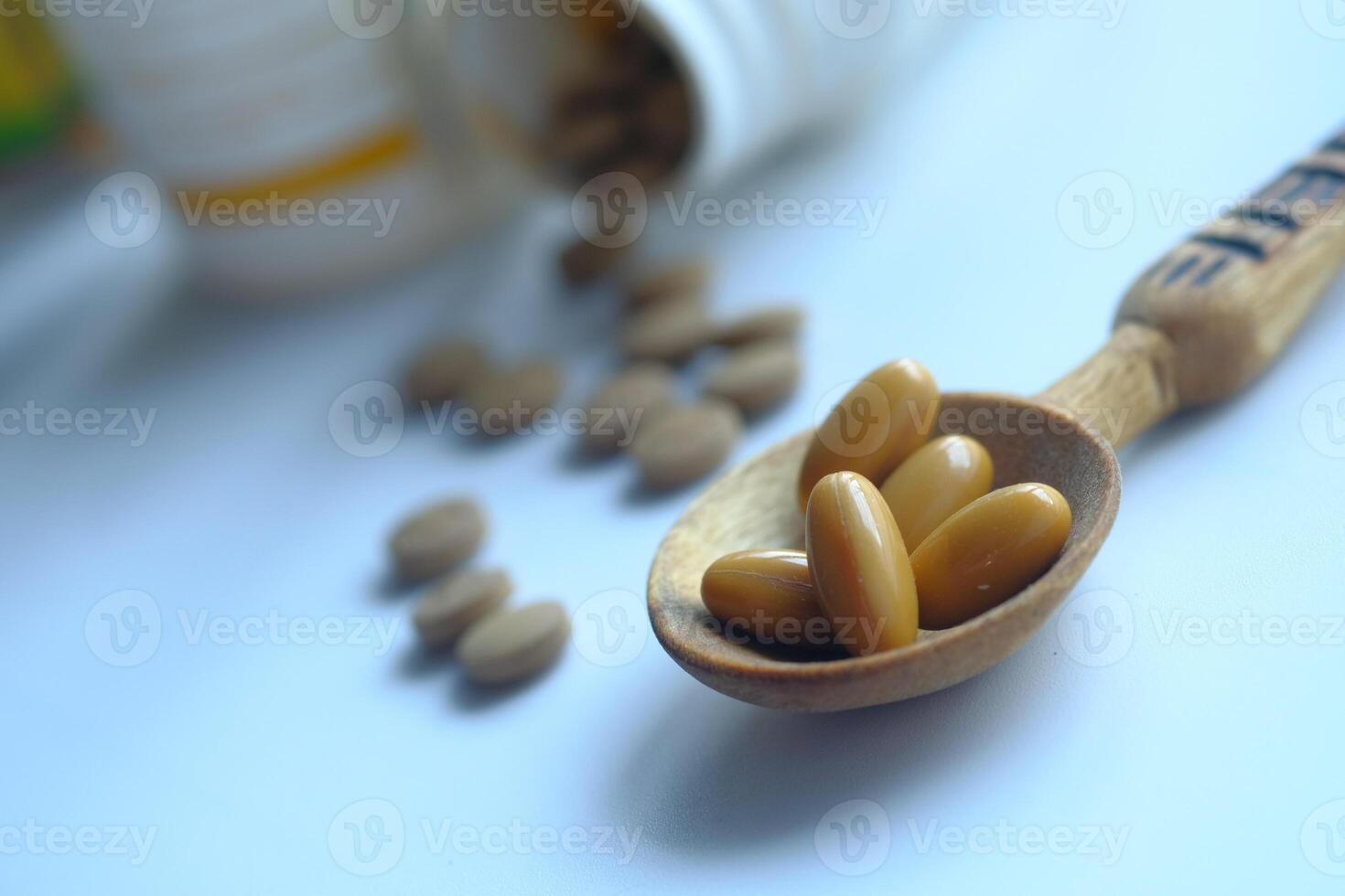 A Spoonful of Healthy Supplements Surrounded by Various Pills and Bottles in the Background photo