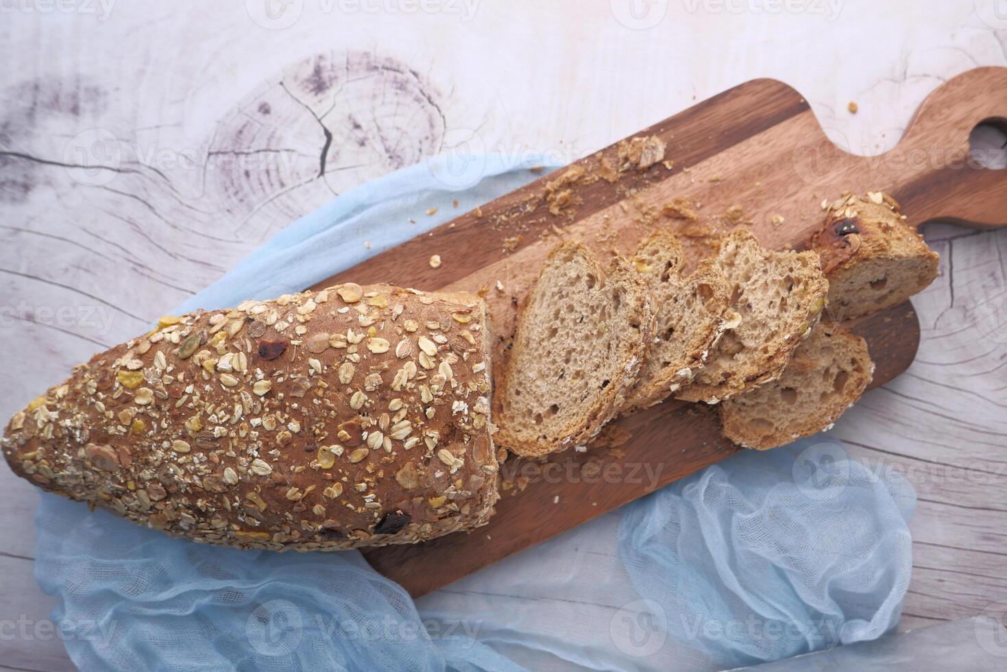 Artisan Whole Grain Bread, enriched with nutritious Oats, resting on a Cutting Board surface photo