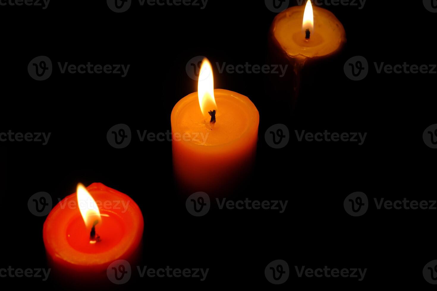 Three Beautifully Glowing Candles Positioned Against a Dark Background for Aesthetic Appeal photo