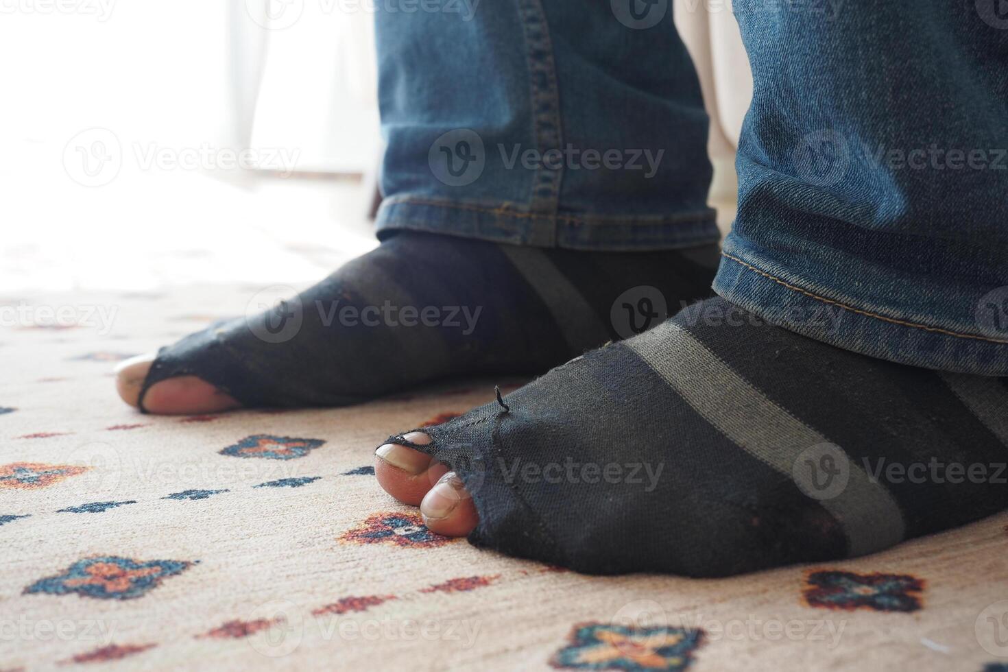 men feet with dirty socks while sitting on sofa photo