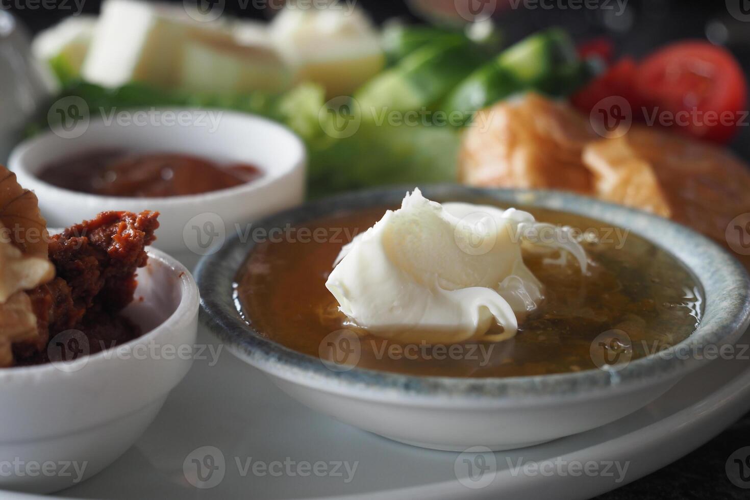 butter cream and honey in a bowl on table . photo