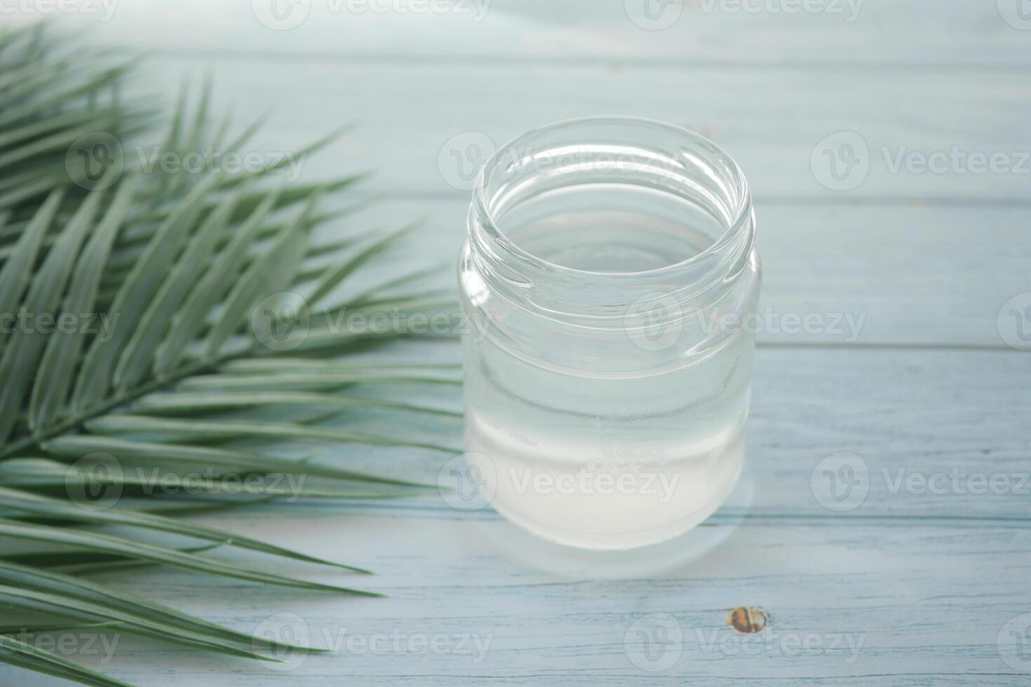slice of fresh coconut and glass of coconut water on table photo