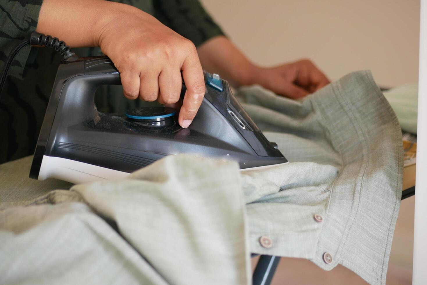 A person is busy ironing clothes on an ironing board in their comfortable home setting photo