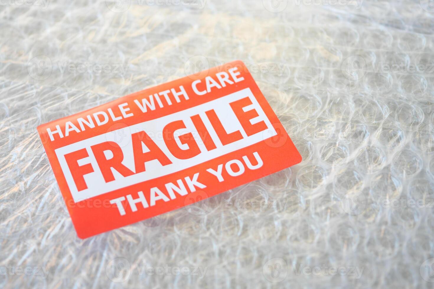 A cardboard box marked with a caution label for fragile goods handling during shipping photo