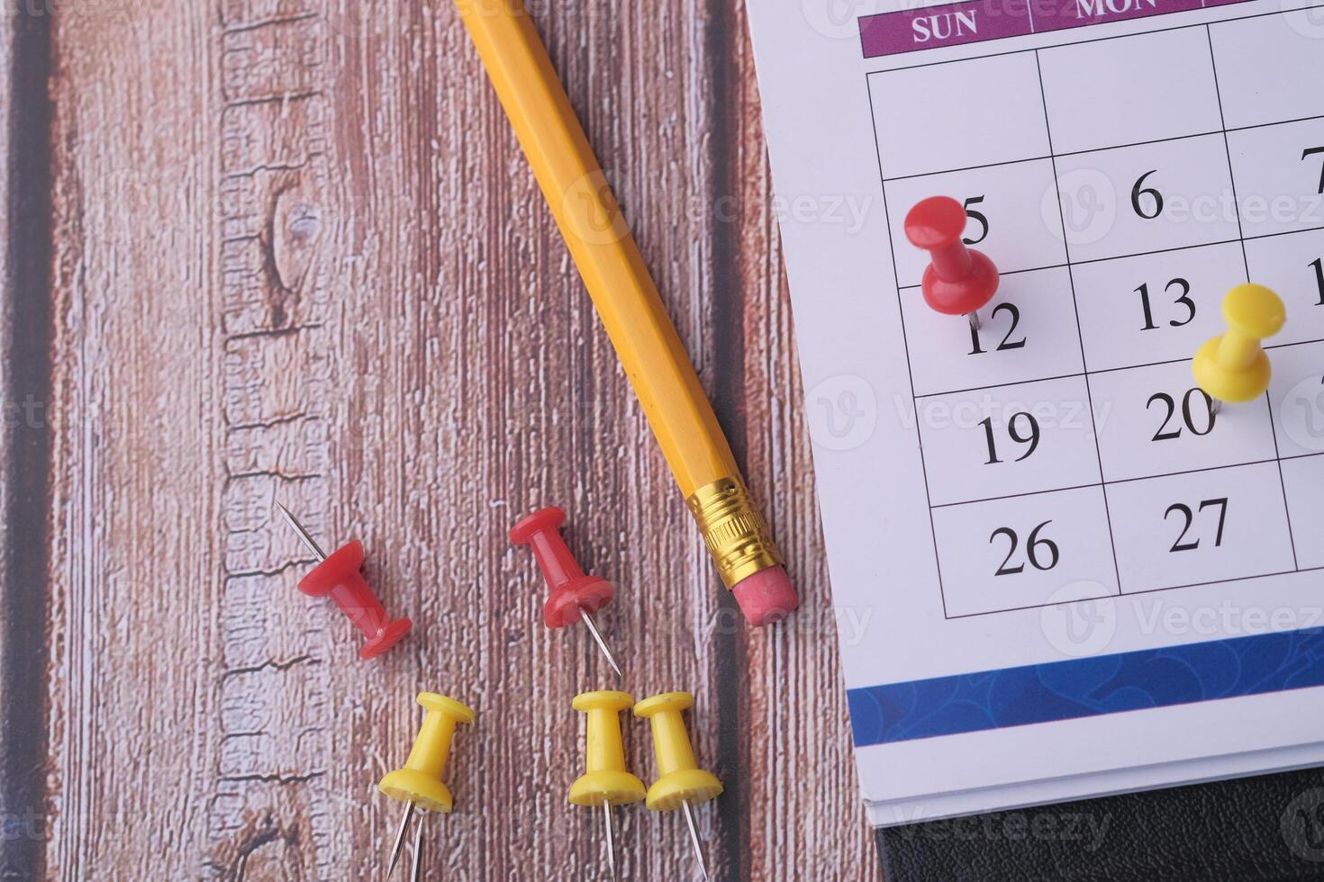 Vibrant and Colorful Office Supplies Arranged on a Wooden Desk Next to a Calendar photo